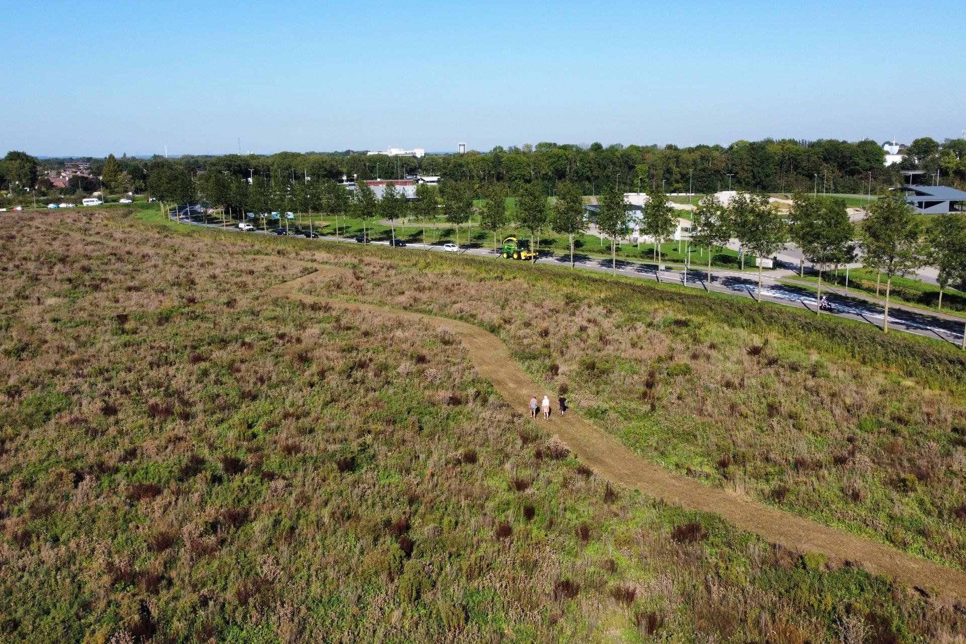 Met een drone in beeld gebracht waar het park Lingerijck gaat komen. Op het pad zie je drie mensen lopen. 